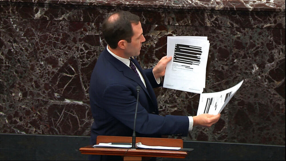 In this image from video, House impeachment manager Rep. Jason Crow, D-Colo., holds up documents released by the Office of Management and Budget (OMB) under a Freedom of Information Act request as he speaks during the impeachment trial against President Donald Trump in the Senate at the U.S. Capitol in Washington, Wednesday, Jan. 22, 2020. (Senate Television via AP)