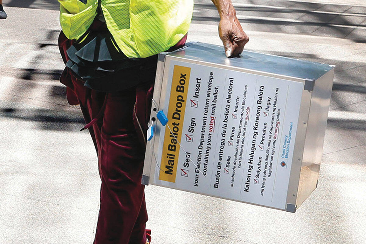 Election workers carry drop boxes out of Las Vegas City Hall for hand-delivered mail-in ballots ...