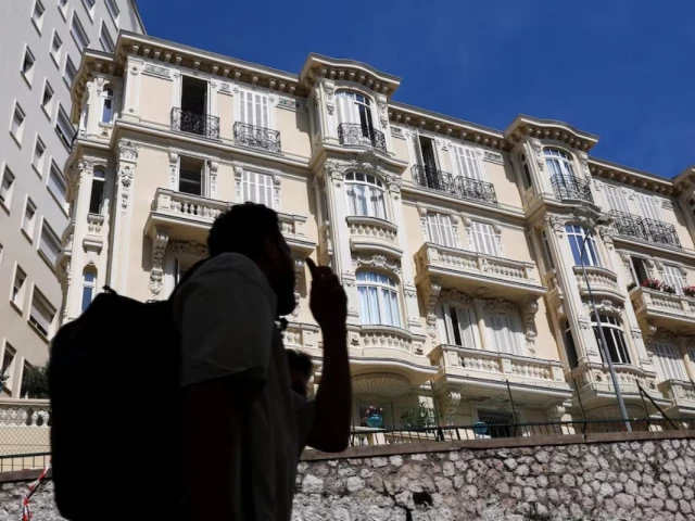 people walk past a residential building the site of an explosion that occurred on monday in monaco reuters