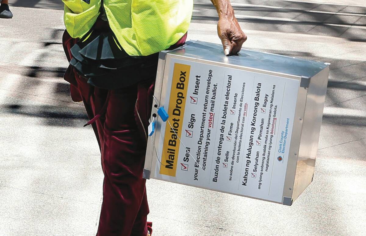Election workers carry drop boxes out of Las Vegas City Hall for hand-delivered mail-in ballots ...