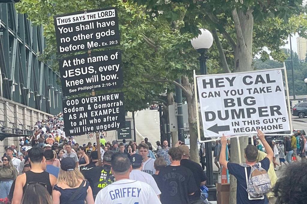 A Mariners fan protests against a Seattle street preacher outside T-Mobile Park on Aug. 2, 2026. (Aaron Coe / The Herald)