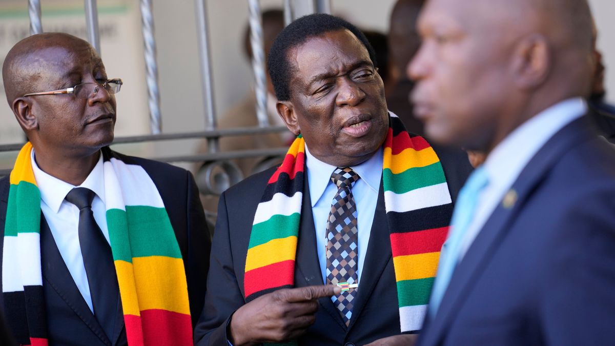 FILE - Zimbabwean President Emmerson Mnangagwa, center, stands next to his chief election agent and Justice Minister Ziyambi Ziyambi, left, outside the nomination court in Harare, Zimbabwe, June 21, 2023. (AP Photo/Tsvangirayi Mukwazhi, File)