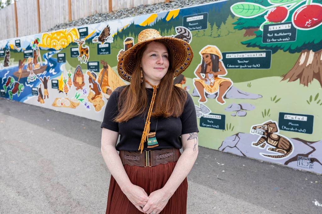 Artist Nakita Strangeways in front of her “A Day on the Stillaguamish River” mural along 211th Place Northeast on Monday, July 20, 2026, in Arlington, Washington. (Olivia Vanni / The Herald)