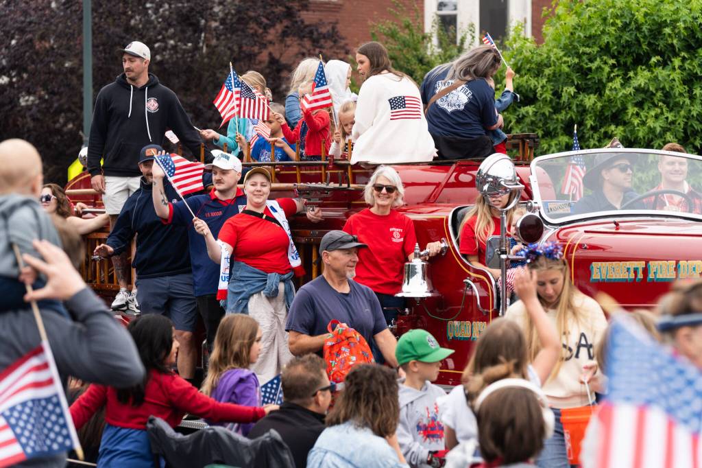 Parade participants ride an Everett Fire Department truck during the Everett Independence Day parade on Saturday, July 4, 2026, in Everett, Washington. (Will Geschke / The Herald)
