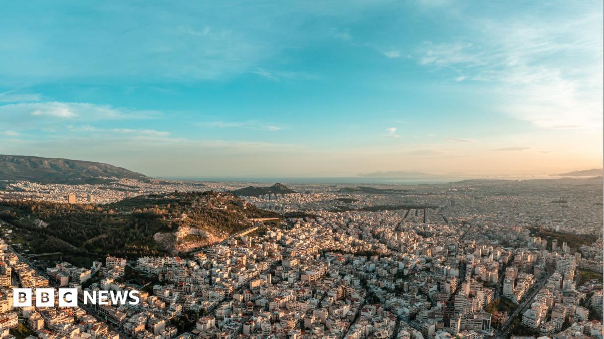 Stock aerial panoramic photo of Athens from the north at sunset, dusk - Psychiko, Chalandri, Marousi, Galatsi, nearby hills and the abandoned quarry of Psychiko up to the seaside