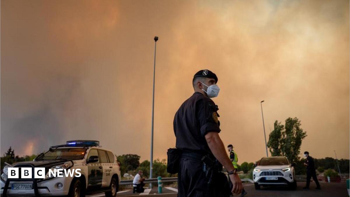 A person runs as the fire spreads in the mountains of Navaluenga, Avila, Spain