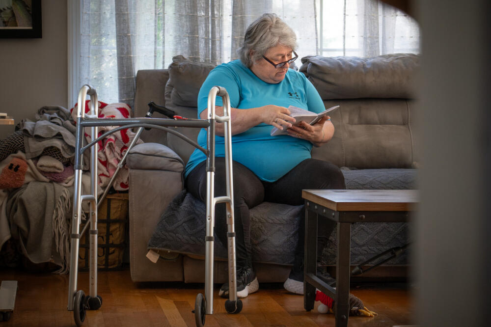 Lynette Couture sits beside her walker on April 10, 2026, at her home in Wareham, Mass., reviewing the journal she kept during her stay in the recovery unit at Plymouth Harborside Healthcare's rehab. (Eleonora Bianchi/The New Bedford Light via AP)