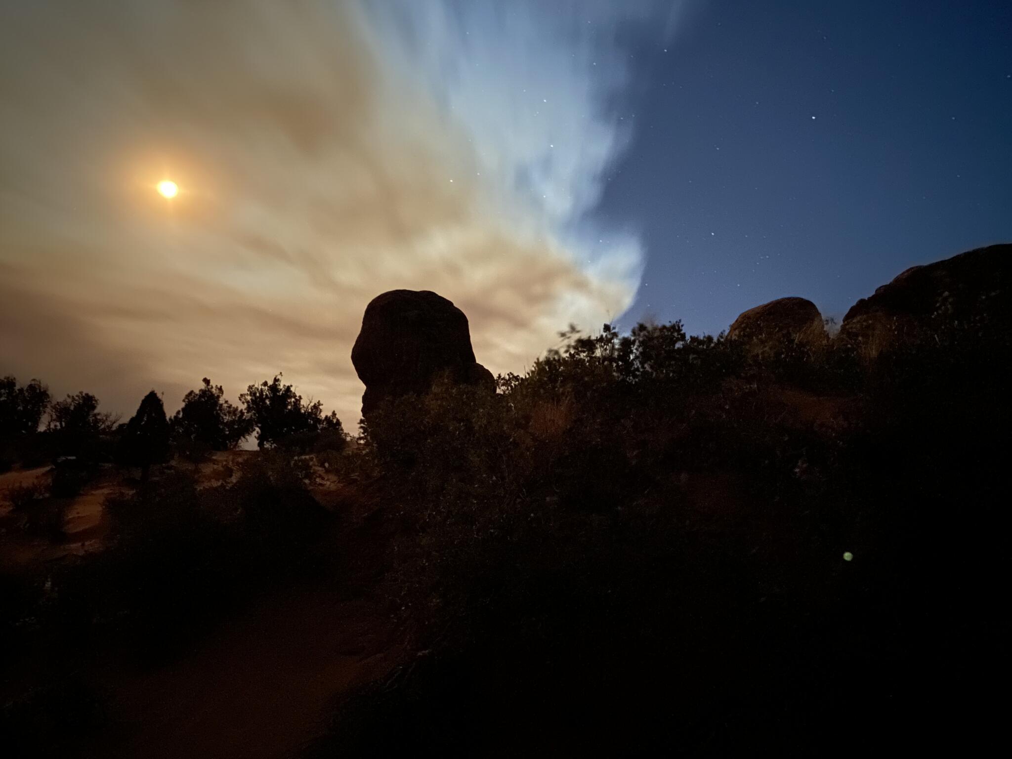 A dark foreground with a smoke-filled sky in the background.