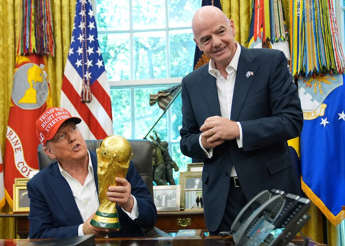 FILE - President Donald Trump holds the FIFA World Cup Winners Trophy as FIFA President Gianni ...