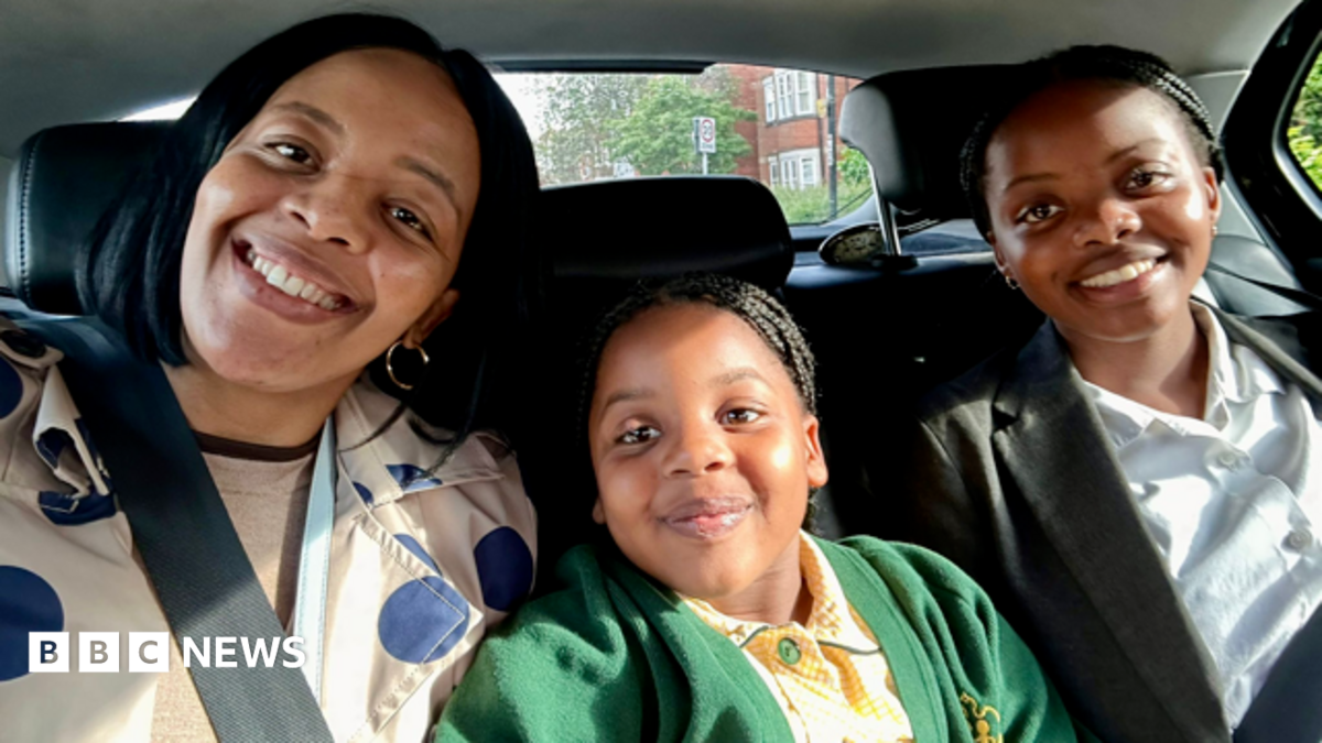 A smiling family sat together in the back seat of a car