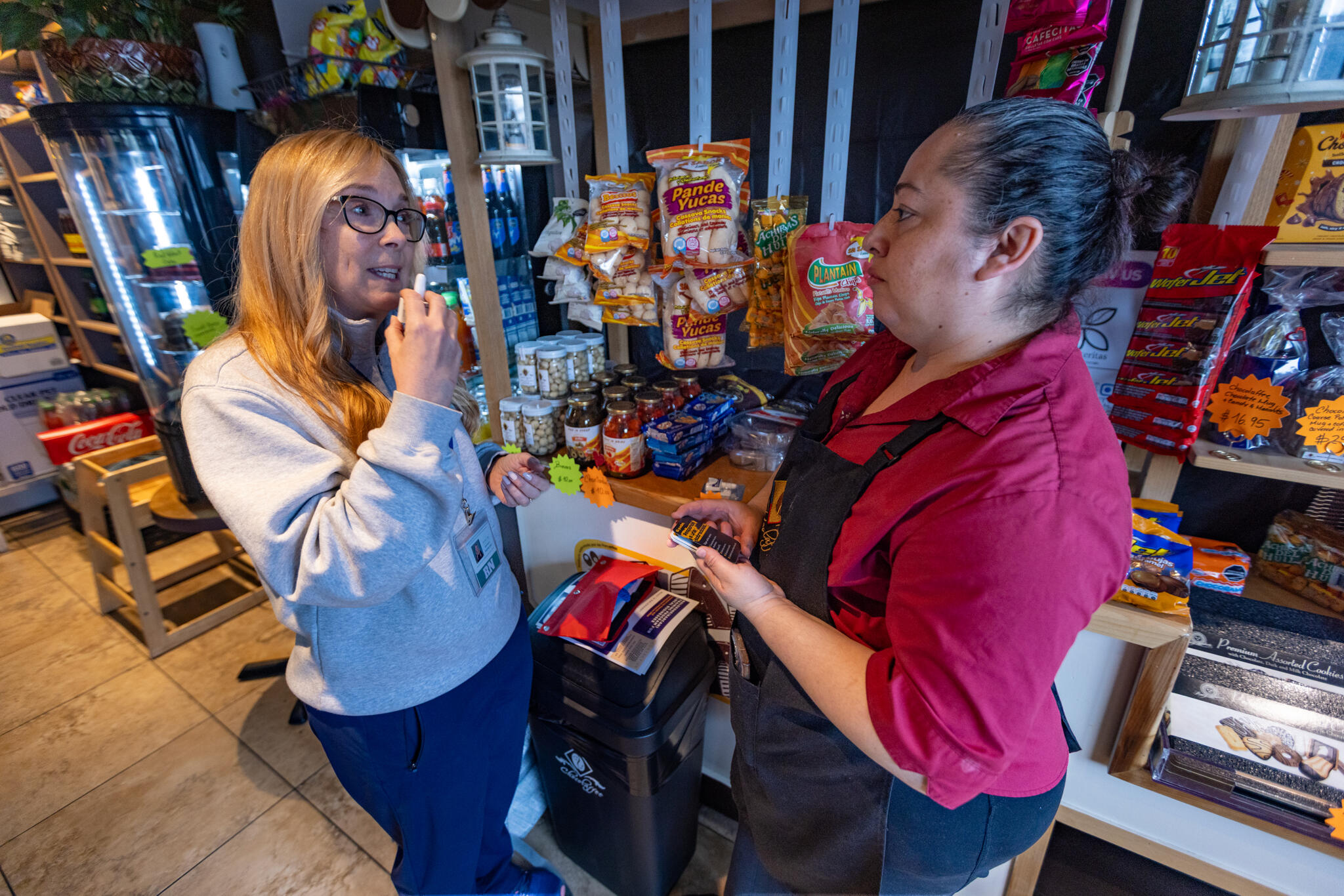 Registered nurse Denise Hartley, co-founder of Atlantic Hill Nursing and Wellness, demonstrates to cafe owner Diana Cardona how to administer naloxone. (Jesse Costa/WBUR)