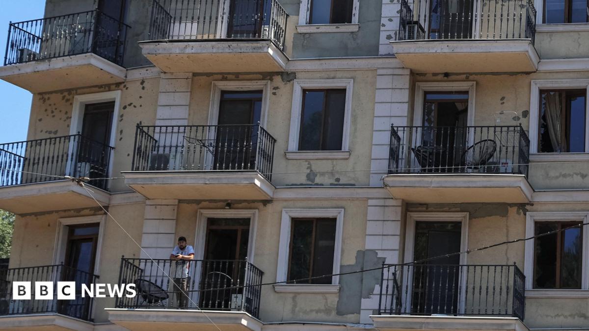 A resident stands on a balcony of an apartment building damaged by a Russian missile strike, amid Russia's attack on Ukraine, in Odesa, Ukraine. Ph July 15, 2026.
