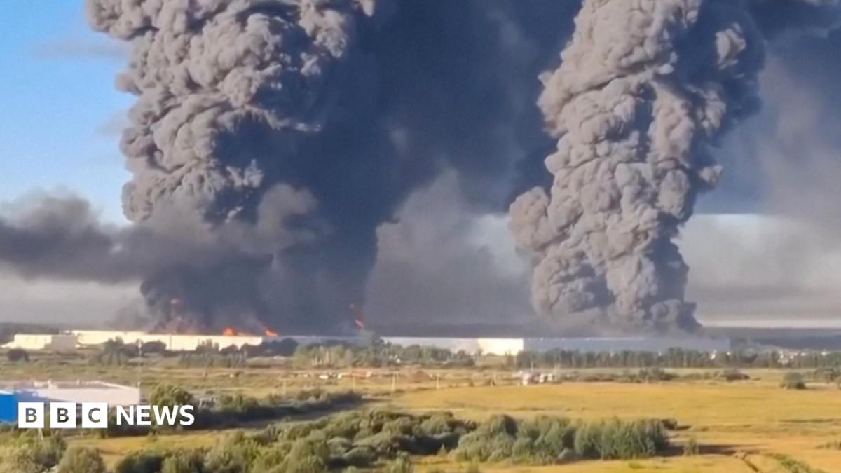 people walk away from a burning warehouse