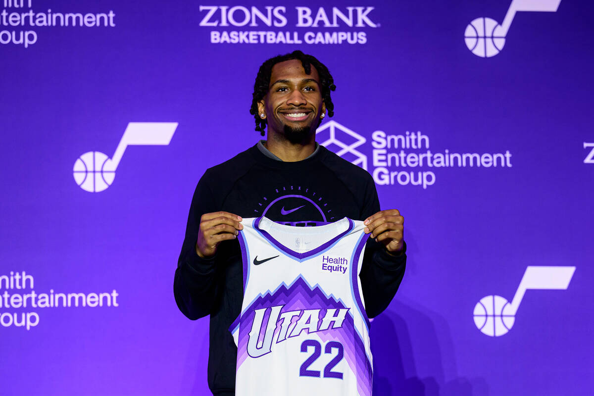 Darryn Peterson holds up his jersey during a press conference for the Utah Jazz No. 2 overall d ...
