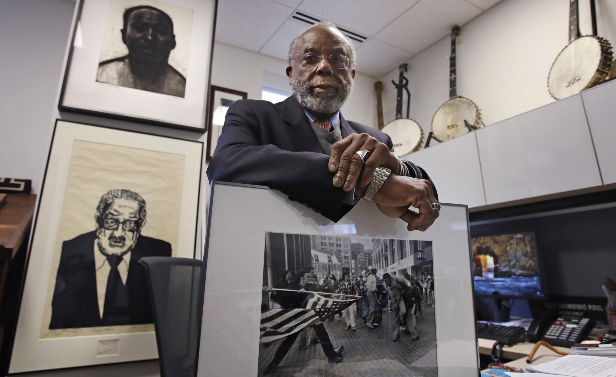 Theodore Landsmark, lawyer, architect and director of the Dukakis Center for Urban and Regional Policy at Northeastern University poses for a photo in his office in Boston, Tuesday, March 27, 2018. Pictured in Landsmark's office are a sketch of King, top left, a portrait of Supreme Court Justice Thurgood Marshall, bottom left, and a Pulitzer Prize-winning photograph by Stanley Forman, which shows Landsmark being assaulted in 1976 by a demonstrator carrying a flagpole bearing the American flag. (Charles Krupa/AP)