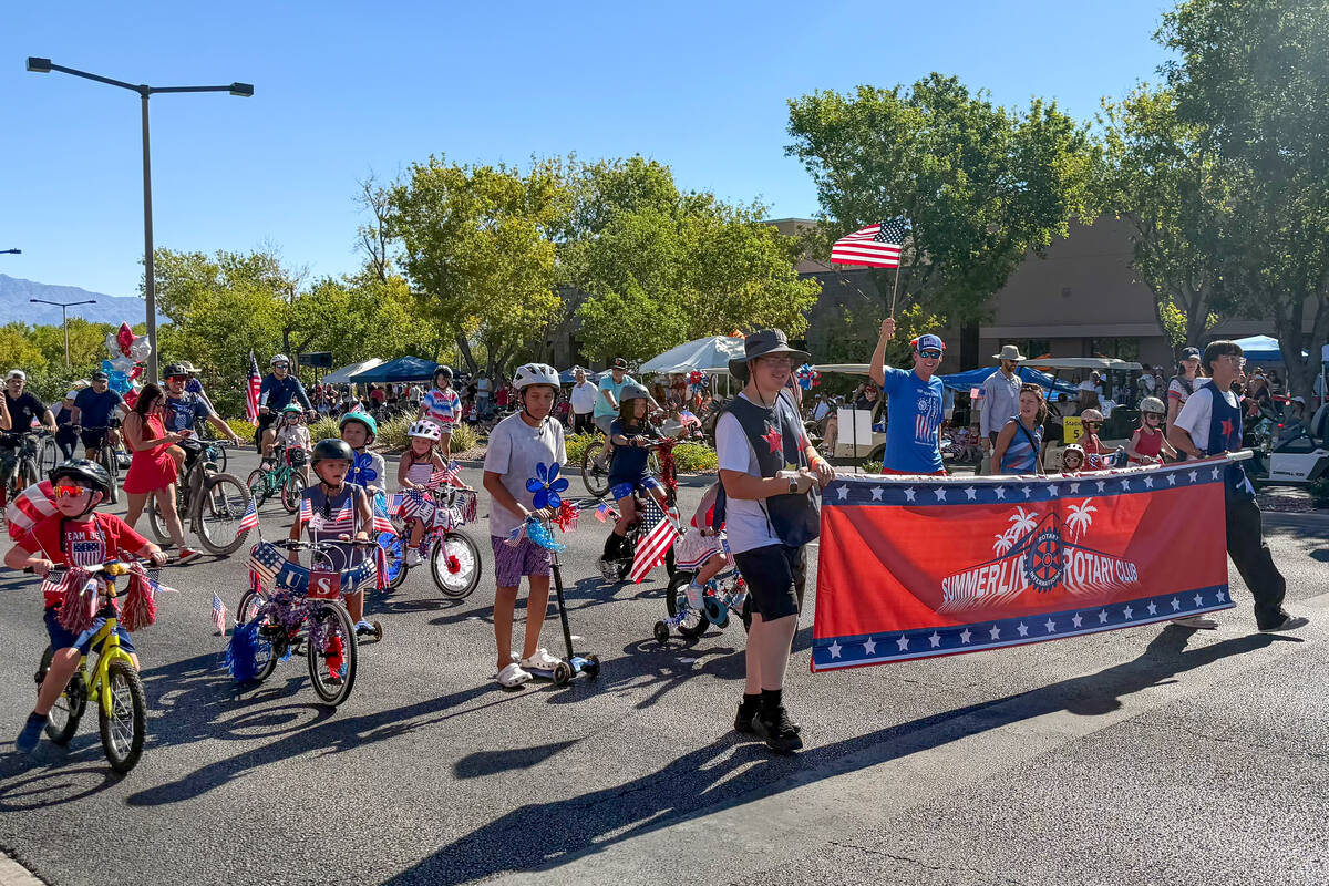 Children ride their bikes before the main section of the Summerlin Council Patriotic Parade beg ...