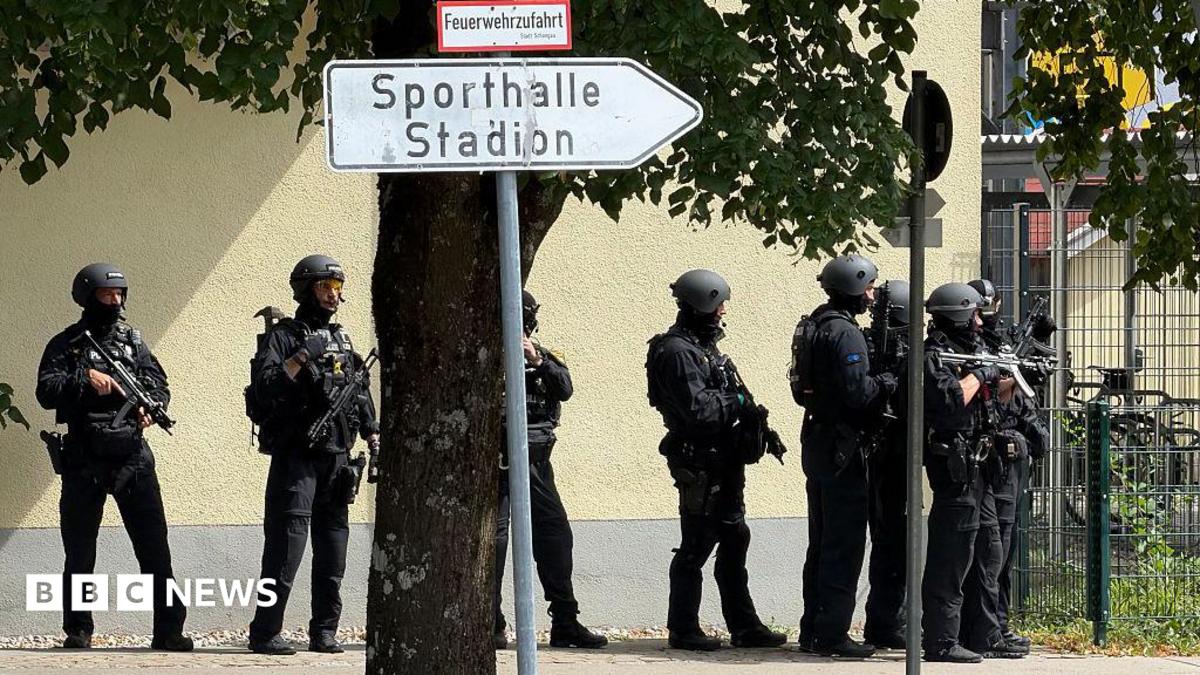 Police officers stand with guns outside a school in Germany.