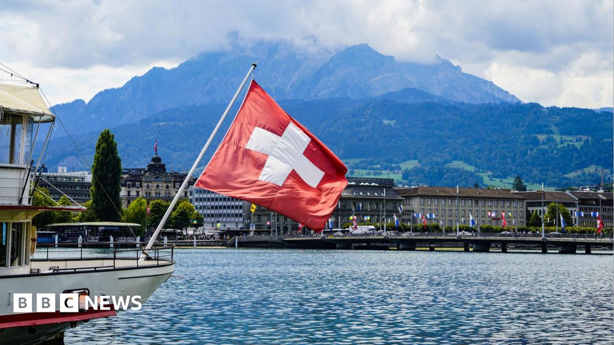 A view of a Swiss flag on a boat on lake Lucerne and Lucerne city in central Switzerland