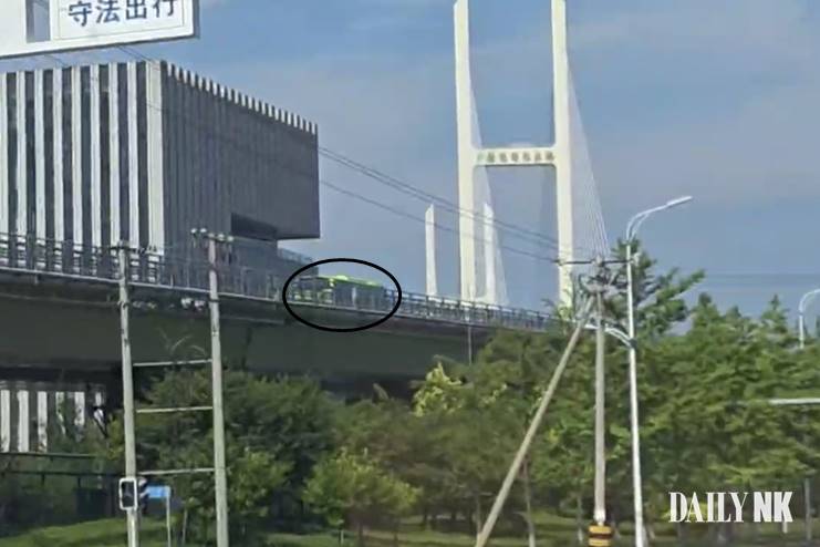 Bus crossing the New Yalu River Bridge toward Sinuiju, North Korea