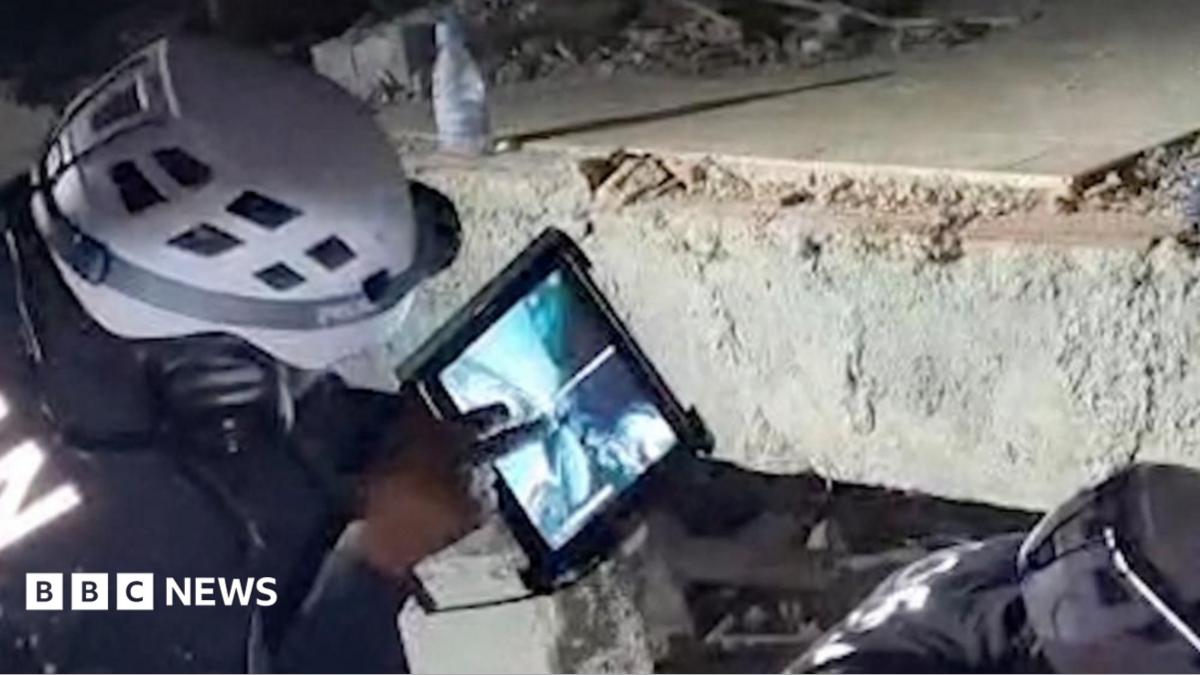 A Jordanian team works to rescue a child trapped under rubble following earthquakes in Venezuela.