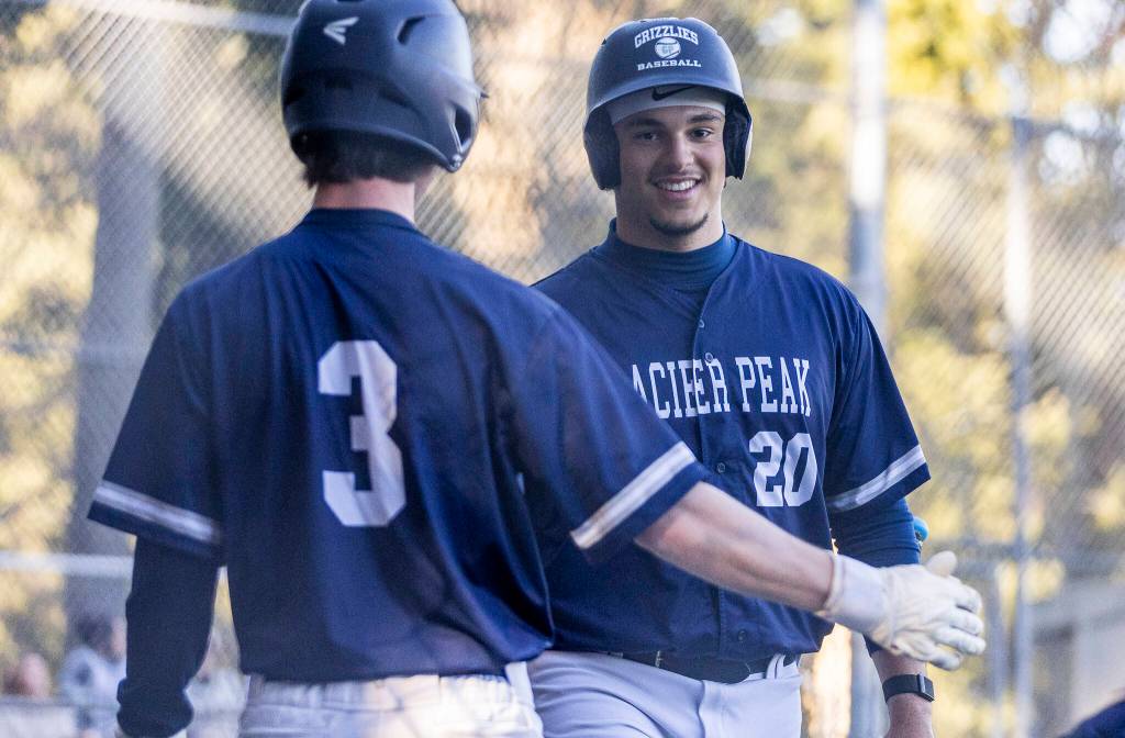 Glacier Peak’s Emmett Brown high-fives Matthew Marquardt after scoring during the game against Meadowdale on Wednesday, April 8, 2026 in Lynnwood, Washington. (Olivia Vanni / The Herald)