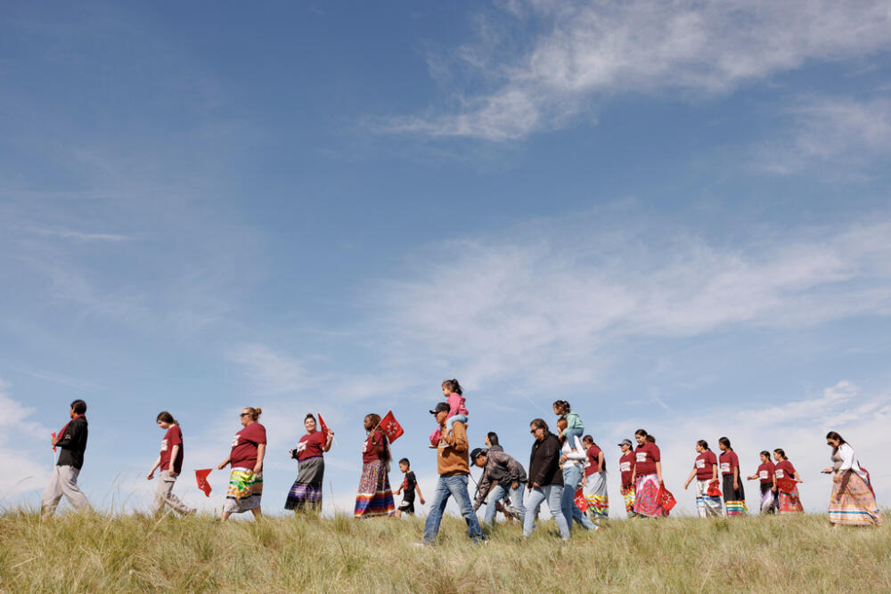 Attendees walk to the charging event during festivities to commemorate the 150th anniversary of the Battle of the Little Bighorn in Crow Agency, Mont., on Thursday, June 25, 2026. (AP Photo/Tailyr Irvine)