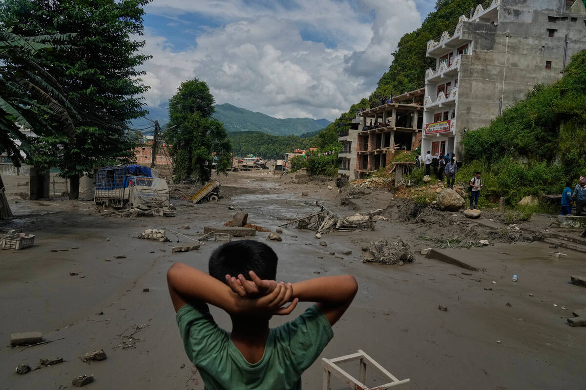 A boy looks at the devastation caused by flash flooding along the Trishuli River in Nepal' ...