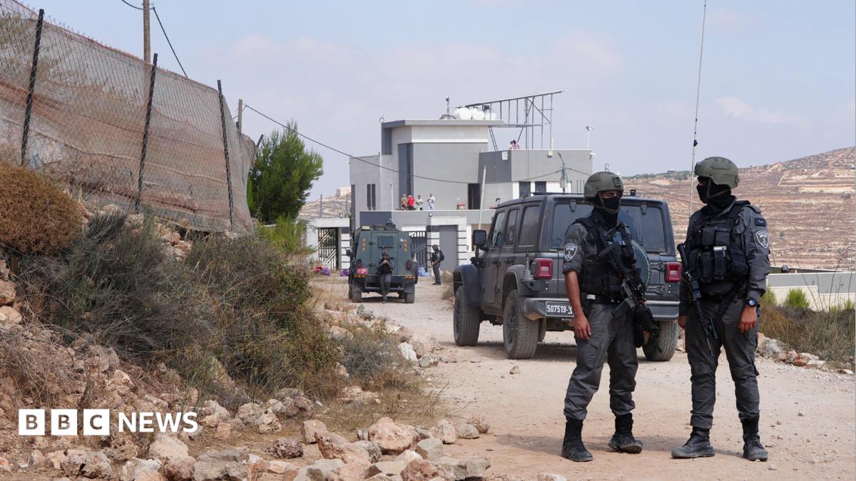 Members of the Israeli security forces stand guard near a Palestinian house, which was besieged by Israeli settlers, in Qusra
