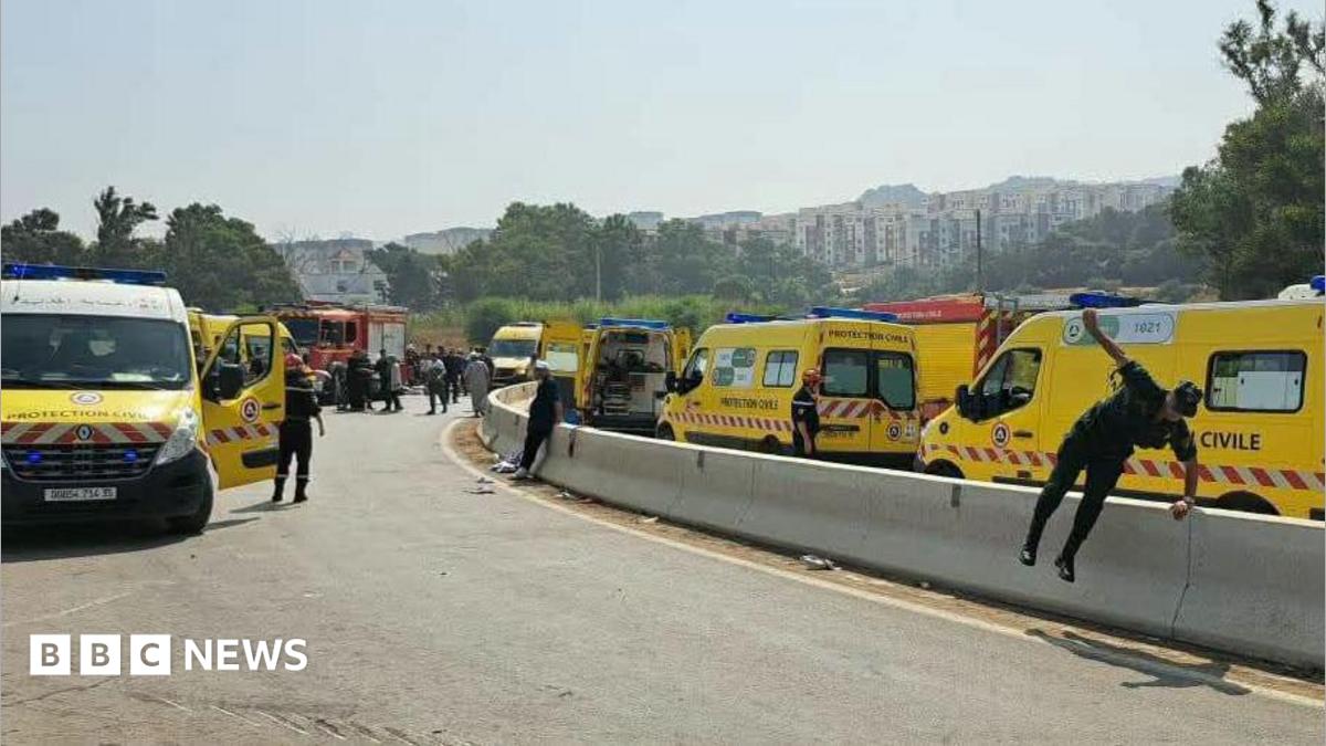 Emergency services near the scene of a coach crash in the Boumerdes region of Algeria. A variety of ambulances can be seen with emergency workers outside them.