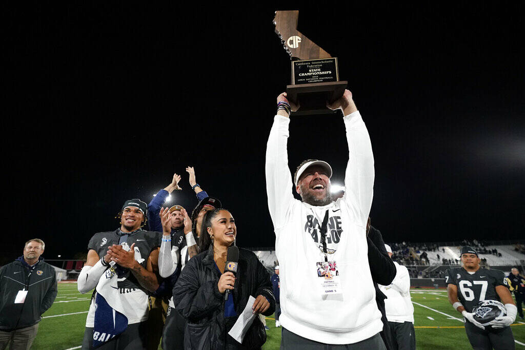 St. John Bosco head coach Jason Negro holds up the championship trophy after winning 45-0 in th ...