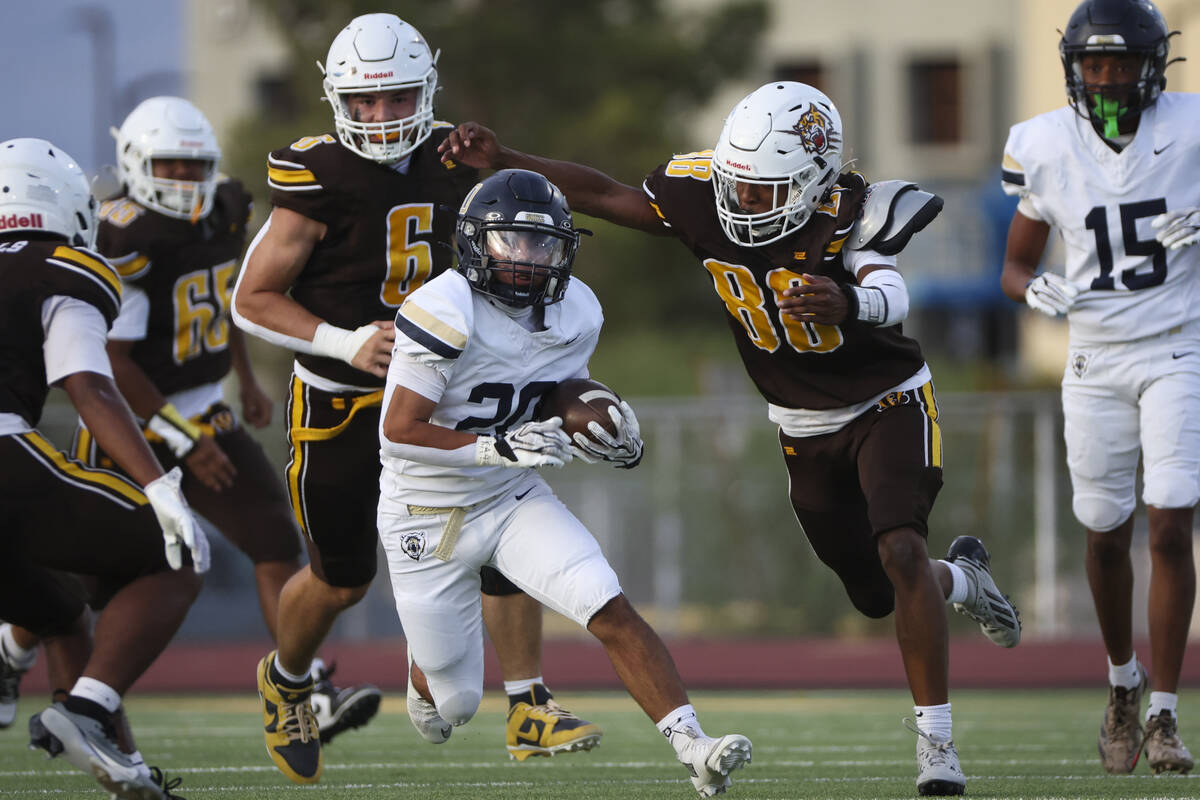 Spring Valley’s Cole Baer (20) runs the ball under pressure from Bonanza’s Josh M ...