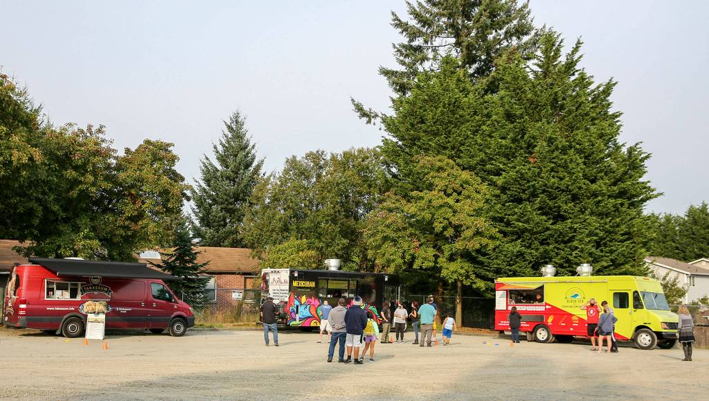 People gather in a parking lot to sample the food truck offering at 6731 Beverly Blvd. in Everett on October 1, 2020. The city has now proposed using the lot for affordable housing. (Kevin Clark / The Herald)