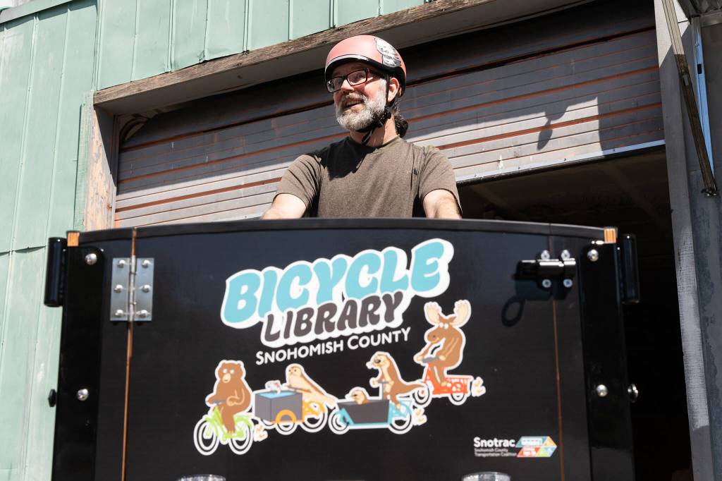 Forrest Baum, the head of the Snohomish County Transportation Coalition’s new e-bike library program, poses for a photo while riding a rental e-bike on Tuesday, June 28, 2026, in Everett, Washington. (Will Geschke / The Herald)