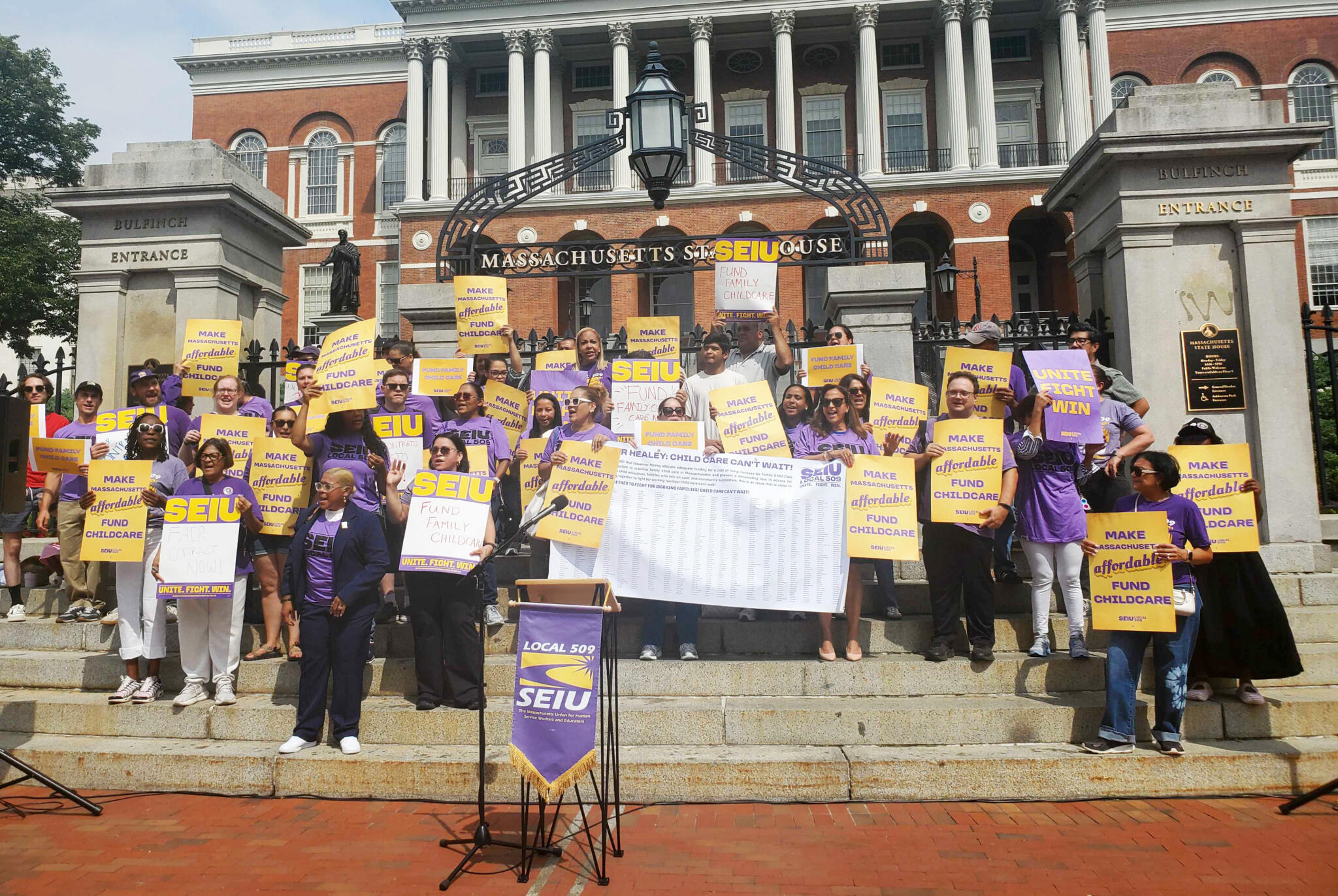 Childcare workers rally on the steps of the State House for higher reimbursement from the state on Tuesday. (Zeninjor Enwemeka/WBUR)