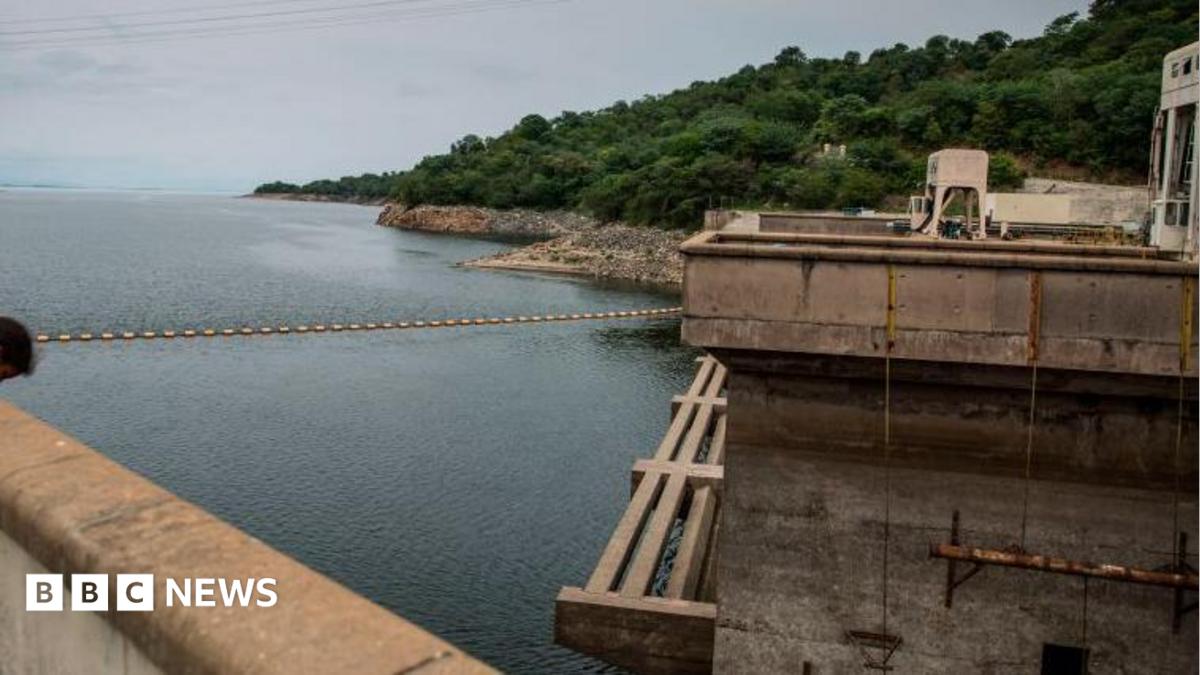 The Kariba dam seen from one of its ridges, overlooking the reservoir and green landscape in the distance