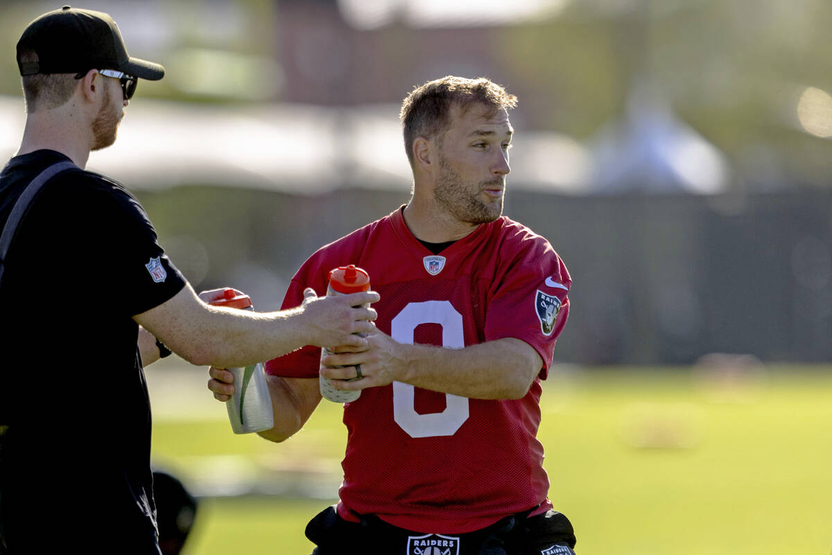 Raiders quarterback Kirk Cousins (8) grabs a drink during an NFL football training camp practic ...
