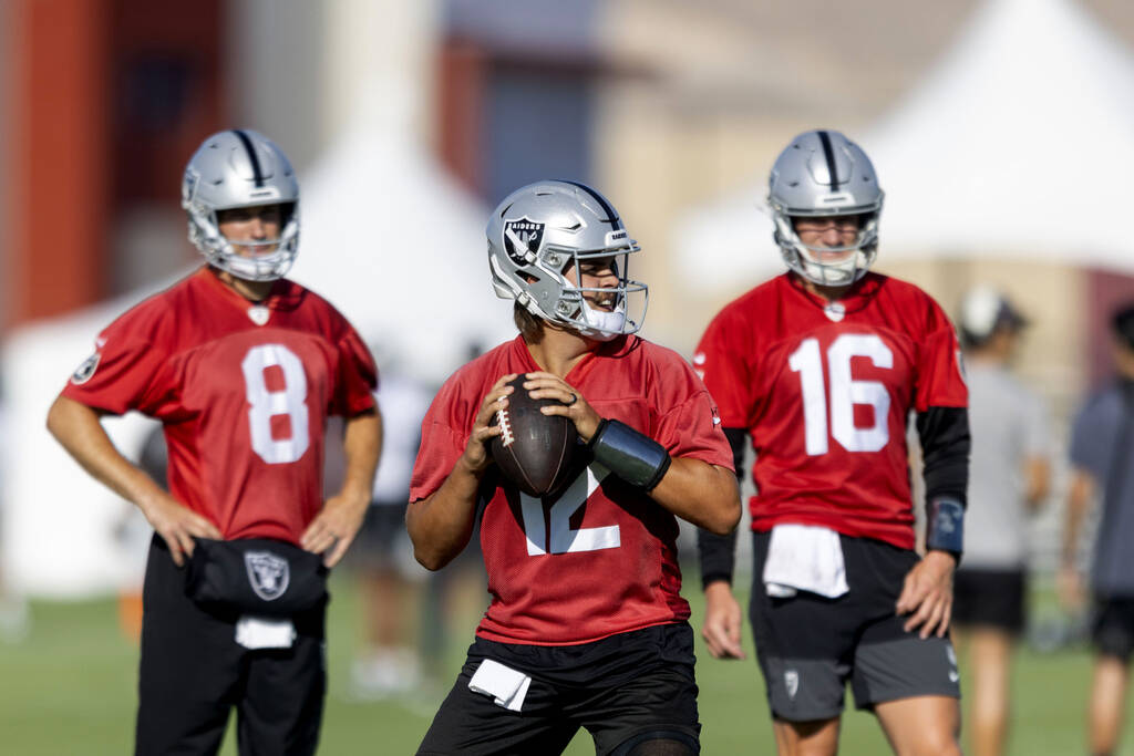 Raiders quarterback Aidan O'Connell (12) prepares to make a throw as quarterbacks Kirk Cou ...