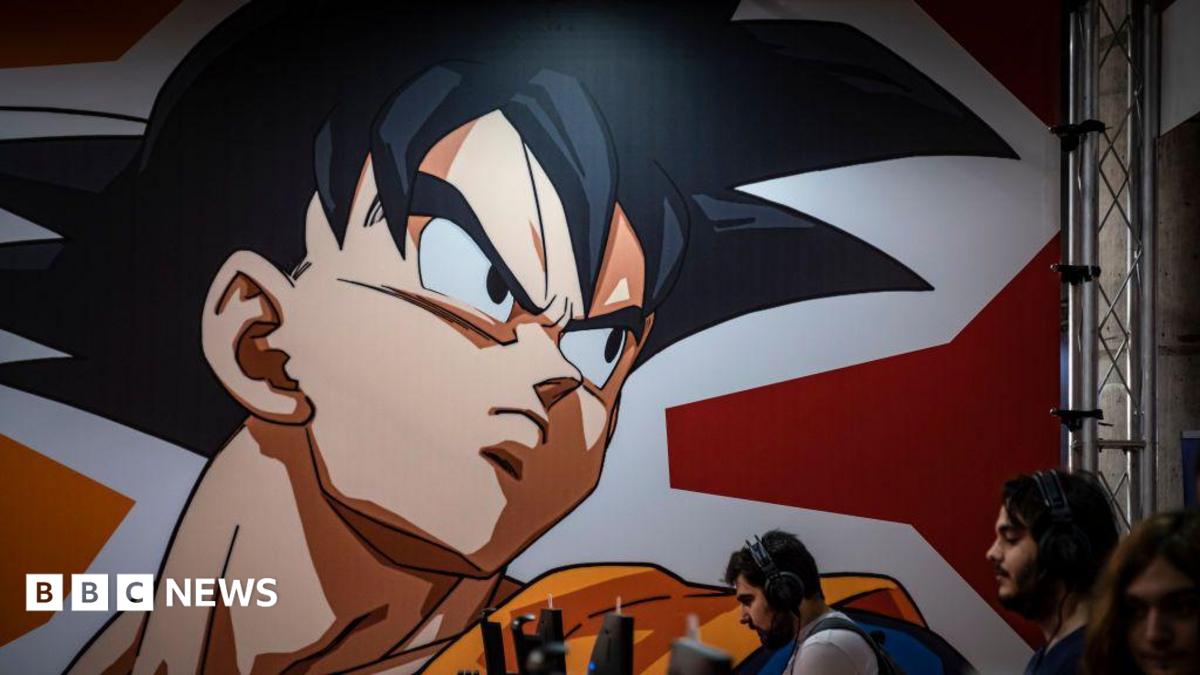 A graphic from the Dragon Ball Z comic is seen displayed on a wall above several people on computers