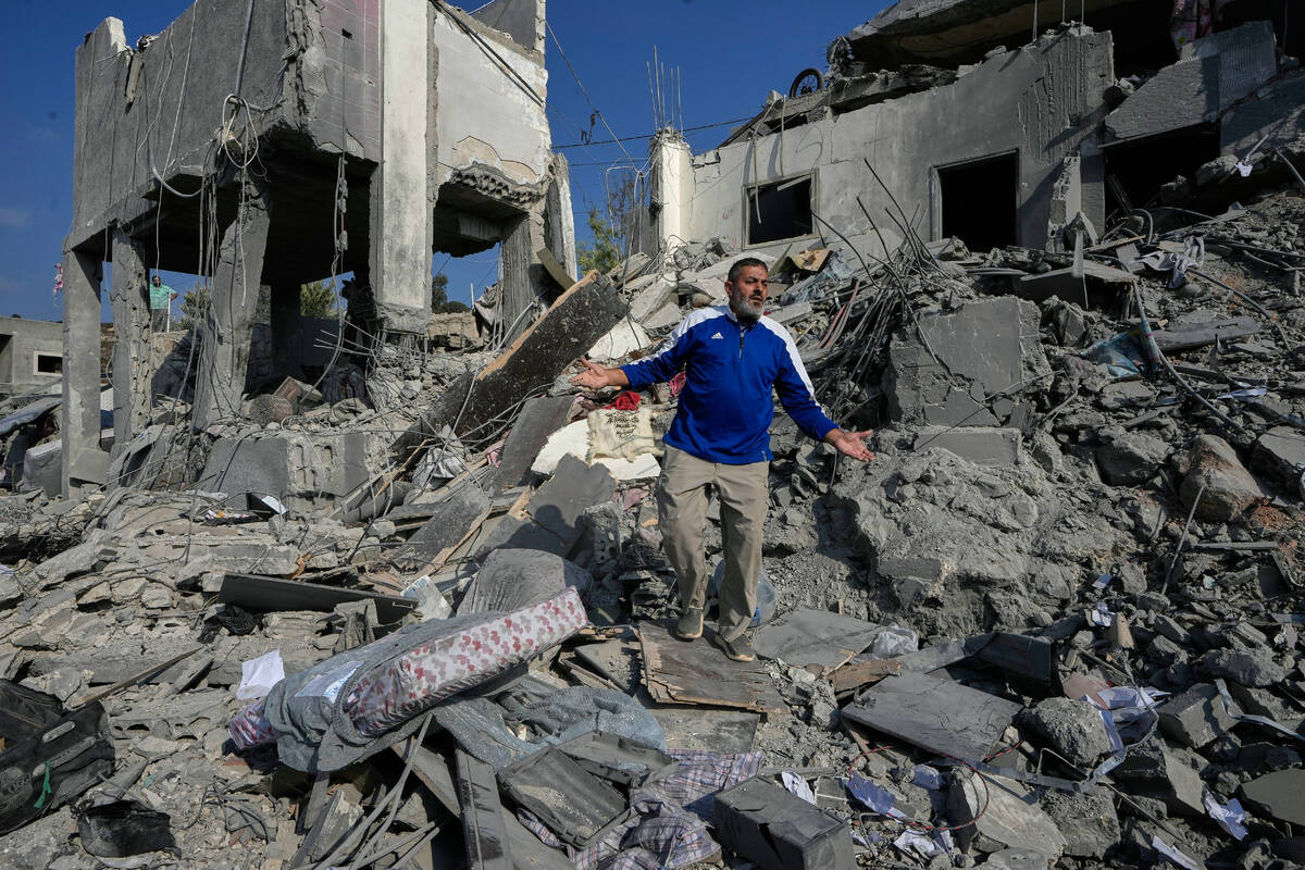A man reacts on the rubble of a destroyed home that was hit by an Israeli airstrike in Ansar vi ...