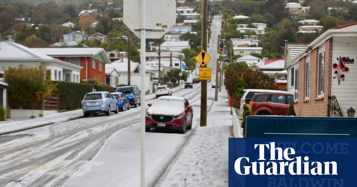 New Zealand capital delights in rare snowfall as southern city residents ski down world’s steepest street | New Zealand