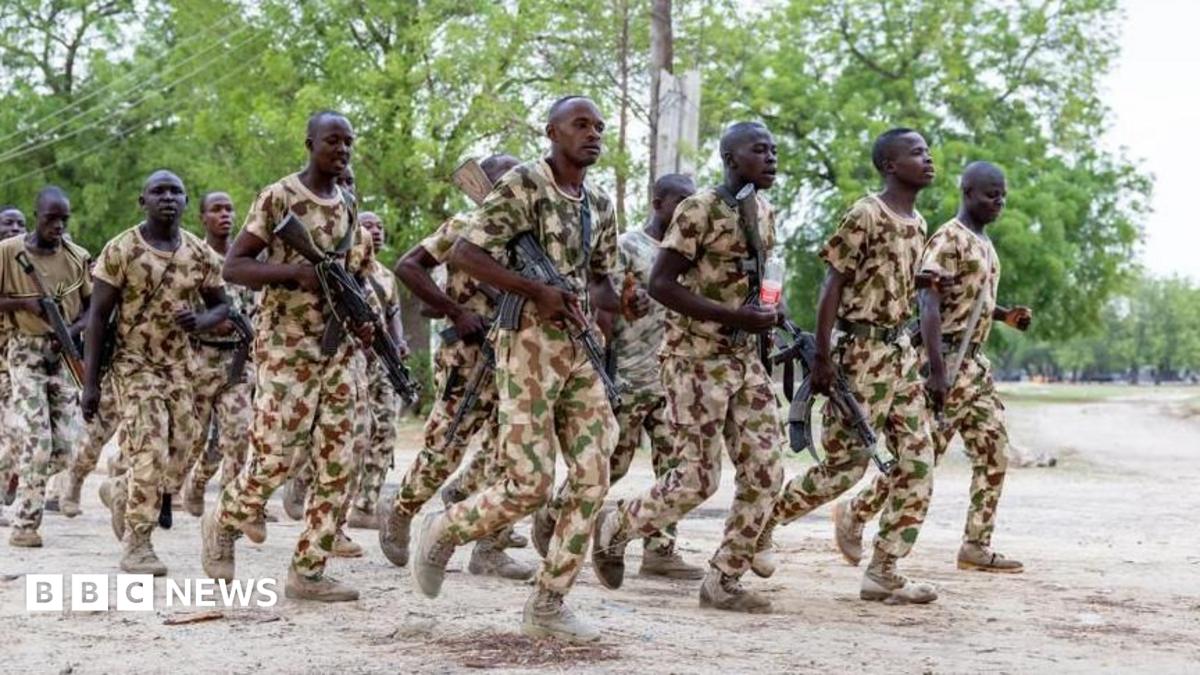 Nigerian soldiers dressed in uniform train while holding guns