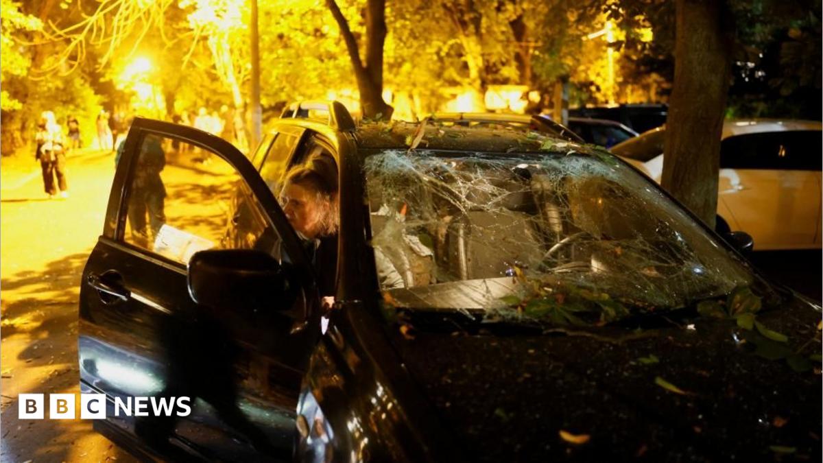 Firefighters work at the site of an apartment building hit by a Russian missile strike in Kyiv