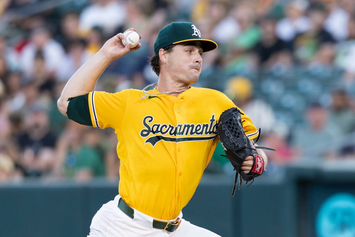Athletics pitcher J.T. Ginn throws to the Texas Rangers during the third inning of a baseball g ...