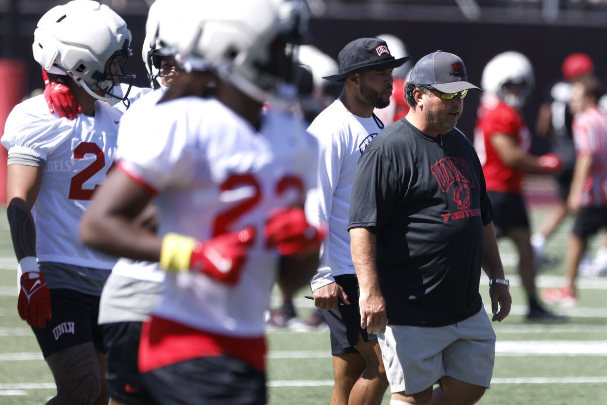 UNLV football interim defensive coordinator Paul Guenther, right, takes the field with his play ...