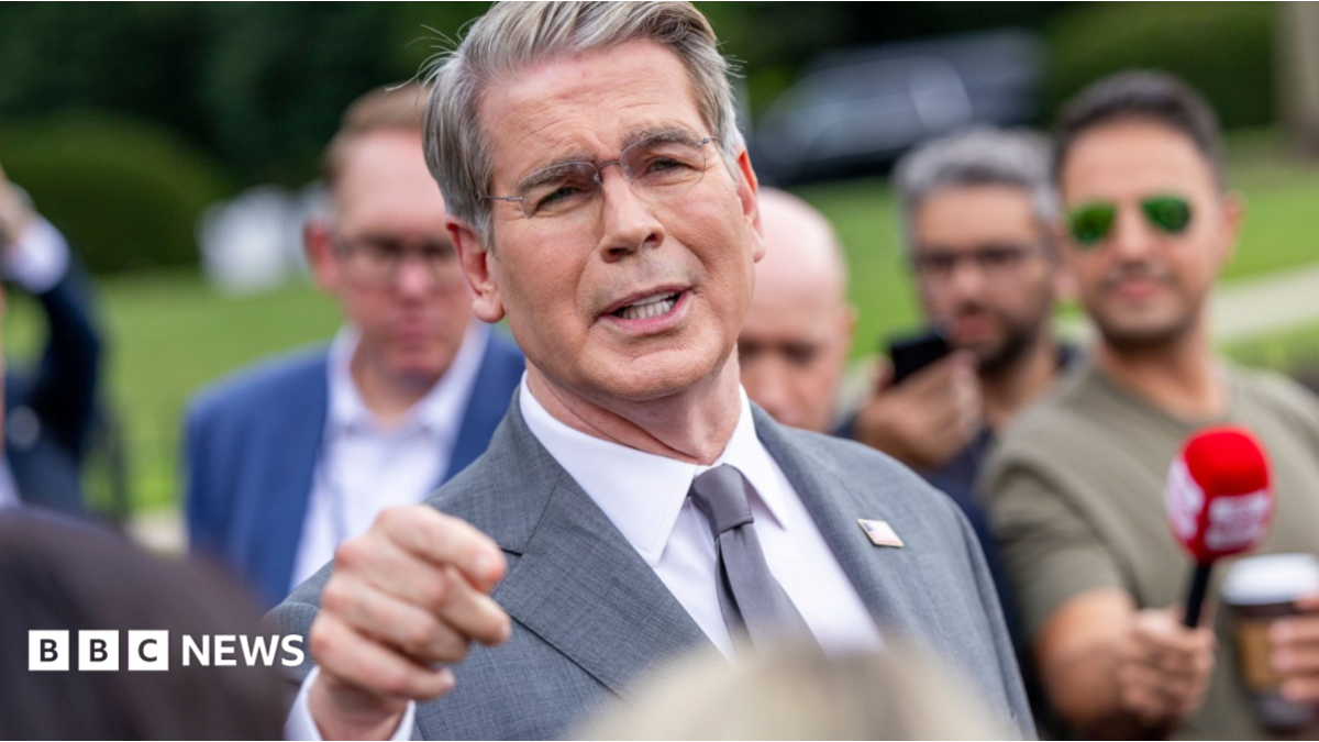 US Treasury Secretary Scott Bessent addresses members of the media on the lawn outside the White House. He's wearing a light grey suit, white shirt and silver tie