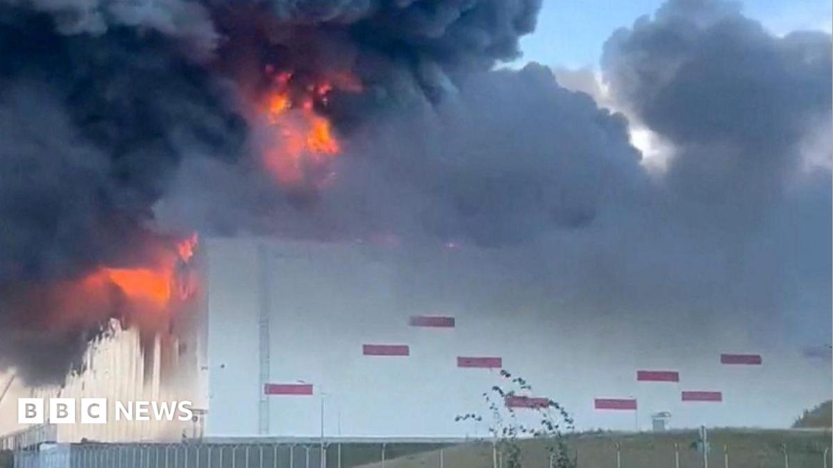 Huge flames and black smoke rise from a warehouse with similar design to other Wildberries warehouses