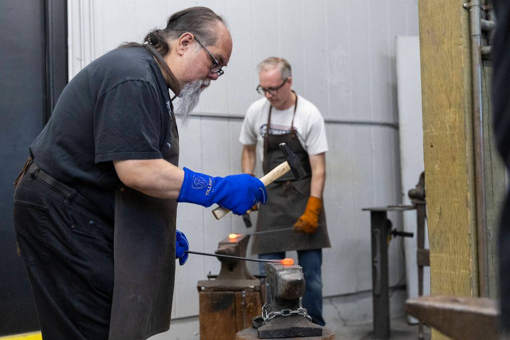 Paul Burton homers his piece of stainless steel damascus during a ring forging class at Lawless Forge on Sunday, May 31, 2026 in Marysville, Washington. (Olivia Vanni / The Herald)
