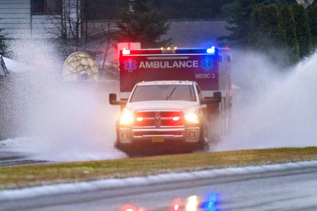 A Capital City Fire/Rescue ambulance splashes through a flooding area of Riverside Drive on their way to a call in this January 2015 photo. (Michael Penn