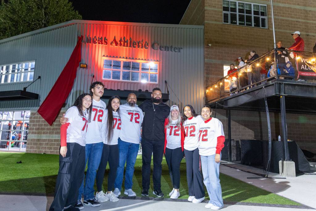 Seahawks offensive lineman Abraham Lucas and his family pose for a photo outside of the newly unveiled Lucas Athletic Center during halftime of an Archbishop Murphy vs. Sehome football game on Friday, Sept. 11, 2026 at Archbishop Murphy H.S. in Everett. (Qasim Ali / The Herald)