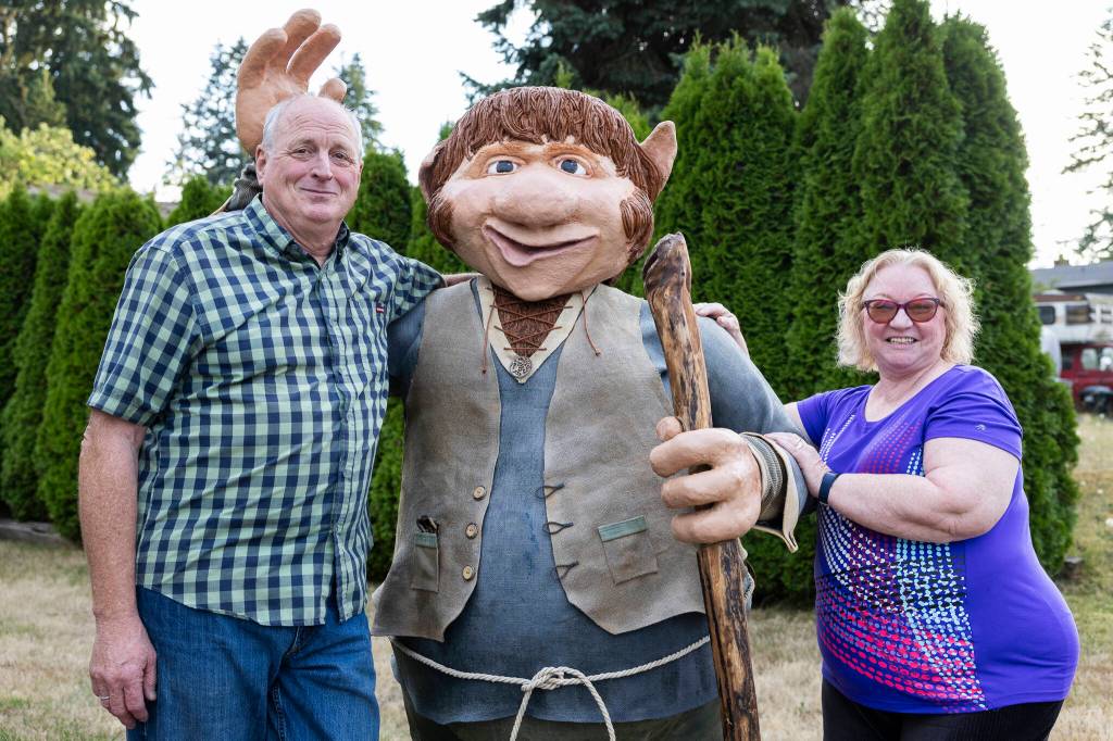 Randy and Jana Compau with their 6-foot yard troll named Jaspar in Everett. (Olivia Vanni / The Herald)
